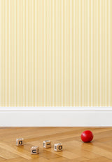 Julia Stripe wallpaper in Jaune in a children's bedroom with a red ball toy