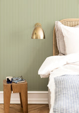 Julia Stripe wallpaper in Vert Olive in a bedroom